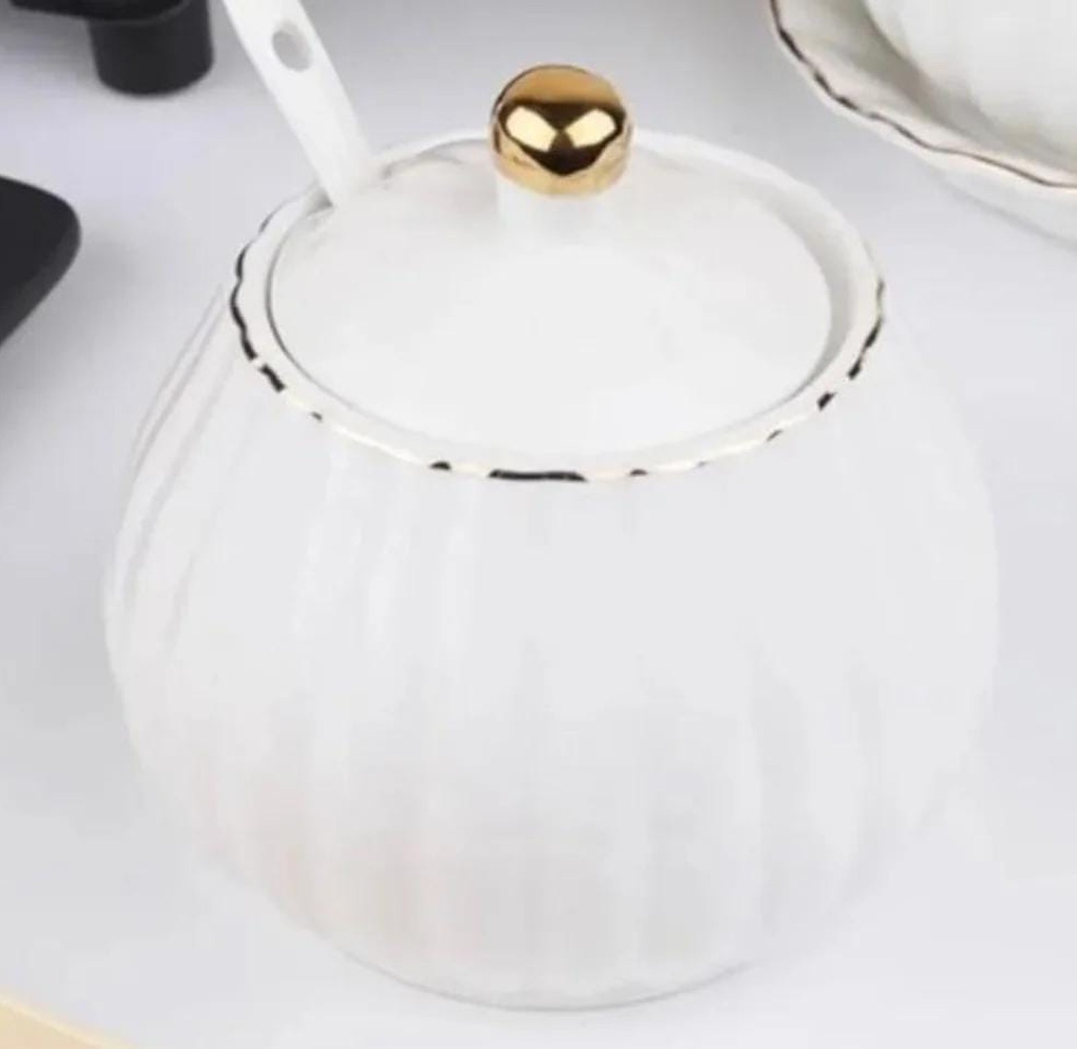 Gold rimmed ceramic sugar dish with spoon image