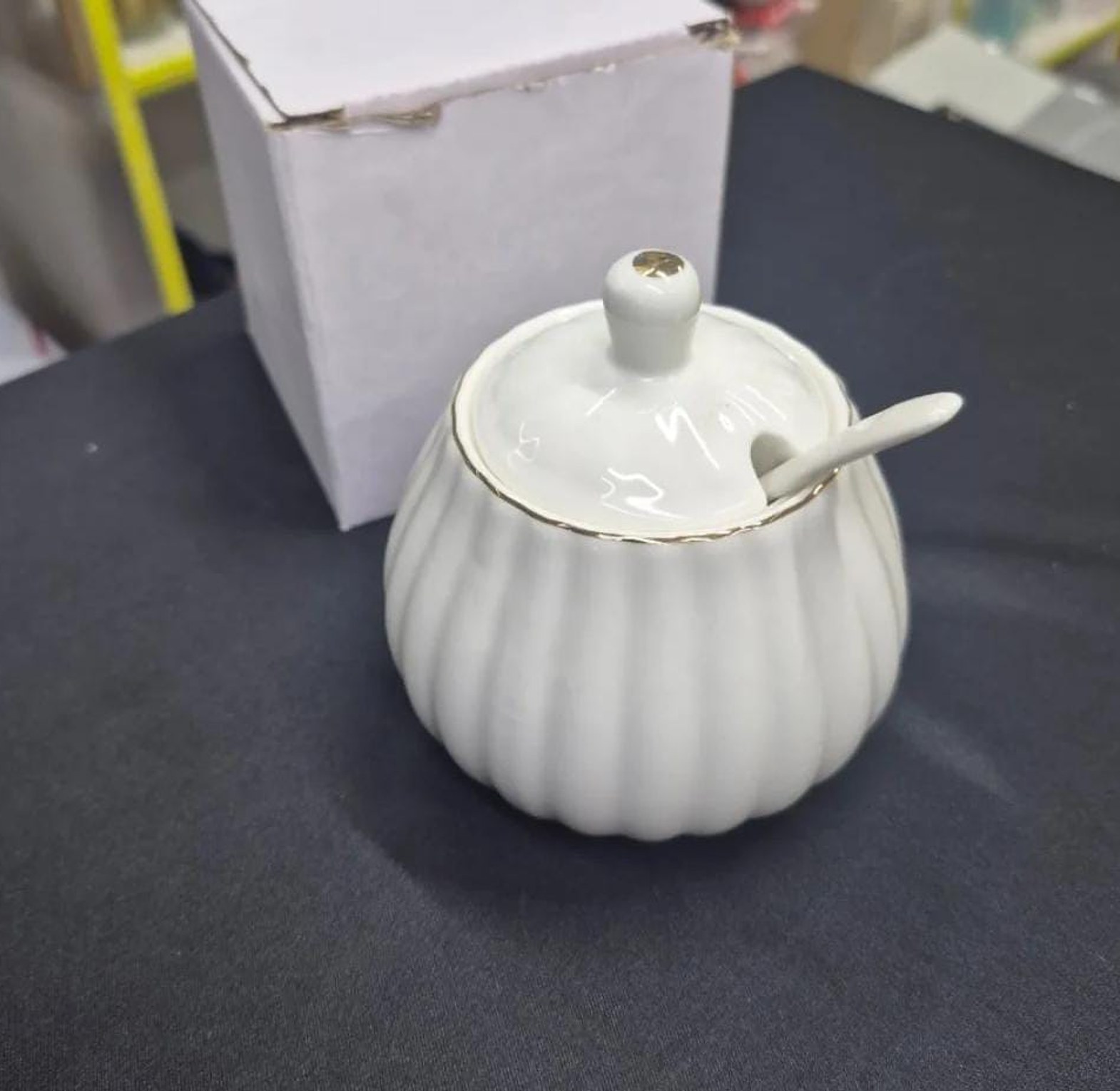 Gold rimmed ceramic sugar dish with spoon image