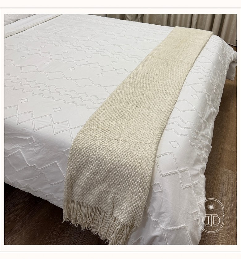 Beige throw blanket with tassels. image